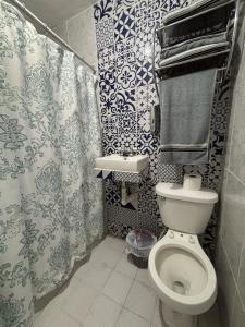 um banheiro com vaso sanitário e cortina de chuveiro em Apartment #3 for 4 WiFi-centric-consulate em Matamoros