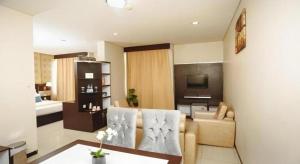 una sala de estar con un sofá y un televisor en Zahra Syariah Hotel Kendari, en Pipulu