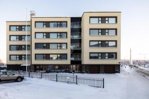 un immeuble d'appartements avec de la neige devant lui dans l'établissement Penthouse Ounas with Private Sauna, à Rovaniemi