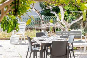 ein Tisch und Stühle in einem Garten mit einem Baum in der Unterkunft Rudy in Campese