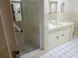 een badkamer met een douche en een wastafel bij Shivon Vaal Guest House in Vanderbijlpark