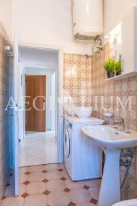 ein Badezimmer mit Waschbecken und Waschmaschine in der Unterkunft Rudy in Campese