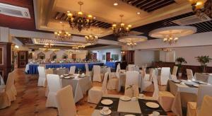 a banquet hall with white tables and white chairs at New century Manju Select Hotel Hongqiao Hub National Exhibition Center in Shanghai