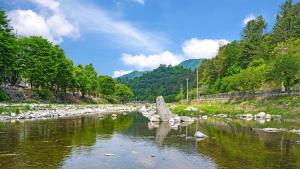 a river with rocks in the water and trees at Gapyeong Yeheaden Pension in Pocheon