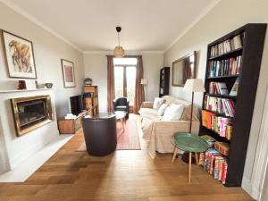 ein Wohnzimmer mit Sofa und Kamin in der Unterkunft Maison avec jardin dans le centre de Cabourg in Cabourg