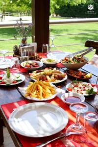 Una mesa cubierta con platos de comida y patatas fritas en Domaine de Chouchene, en Şaḩrat al Qashsh