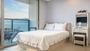 Una cama o camas en una habitación de Yeosu Wayo Ocean View Pension