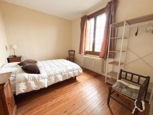 ein Schlafzimmer mit einem Bett und einem Holzboden in der Unterkunft Maison avec jardin dans le centre de Cabourg in Cabourg