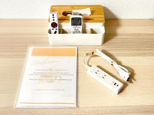 een tafel met een trouwuitnodiging en een Wii-controller bij Camelot House 南福岡 in Fukuoka