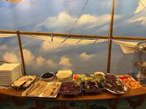 a table with many plates of food on a boat at Old Town Beach in Gaafaru