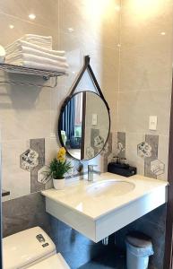 een badkamer met een wastafel en een spiegel bij Hotel Kim Long Hồ Tràm in Kon Rung (1)