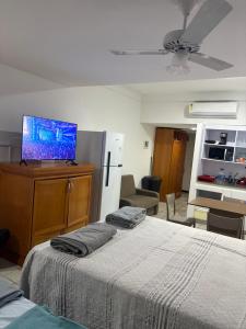 1 dormitorio con cama y vestidor con TV en Praia de Piedade flat frente para o mar, completo Edf Golden Beach, en Recife