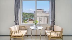 una stanza con un tavolo, delle sedie e una finestra di Gapyeong Ciere Poolvilla a Gapyeong