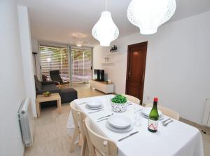 een eetkamer en een woonkamer met een witte tafel en stoelen bij Gaudi Contemporani in Mataró