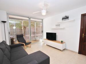 een woonkamer met een bank en een televisie bij Gaudi Contemporani in Mataró