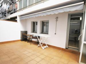 een terras met een tafel en stoelen naast een gebouw bij Gaudi Contemporani in Mataró