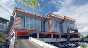 Un gran edificio con coches aparcados en un estacionamiento. en Aria Barito Hotel, en Banjarmasin