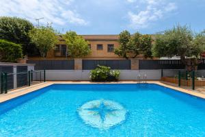 a swimming pool with a umbrella in the water at Aparthotel Vilassar in Vilassar de Mar +78 photos