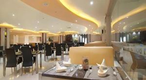 Un restaurante con mesas y sillas en un edificio. en Aria Barito Hotel, en Banjarmasin