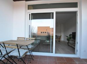 una puerta corredera de cristal que conduce a un patio con mesa en Santa Maria apartment, en Vilassar de Mar 14 fotos más