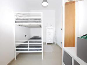 a bedroom with white bunk beds and a desk at Petit niu · Petit niu · Apartamento AC - 3 min de la playa in Vilassar de Mar