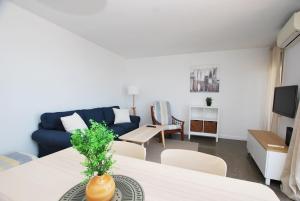 Premia Palm View في بريميا دي مار: غرفة معيشة مع أريكة زرقاء وطاولة