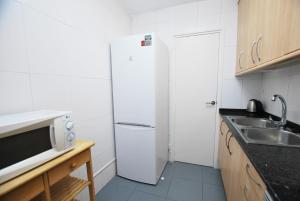 Premia Palm View في بريميا دي مار: مطبخ صغير مع ثلاجة ومغسلة