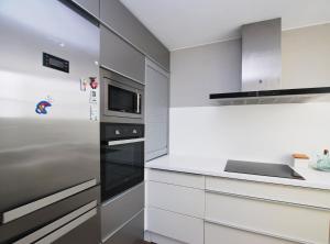 a kitchen with white cabinets and a stainless steel refrigerator at Rey apartment in Vilassar de Mar