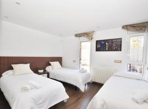 two beds in a room with white sheets at Rey apartment in Vilassar de Mar +28 photos