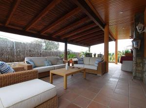 eine Terrasse mit Sofas und einem Tisch auf einer Terrasse in der Unterkunft Villa Magnolia in Mataró
