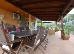 ein Holztisch und Stühle auf einer Terrasse in der Unterkunft Villa Magnolia in Mataró