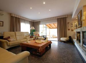 ein Wohnzimmer mit Sofa und Tisch in der Unterkunft Villa Magnolia in Mataró