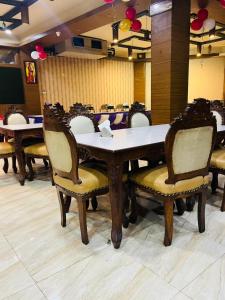 een eetkamer met tafels en stoelen in een kamer bij Hotel LAVENIR in Rohtak