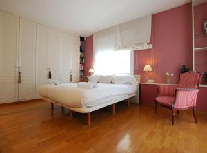 ein Schlafzimmer mit einem großen Bett und zwei roten Stühlen in der Unterkunft Villa Magnolia in Mataró + 39 Fotos