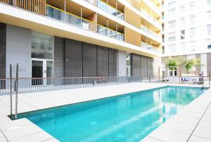 a swimming pool in front of a building at Cozy Home · Cozy Home · Nice apartment w/pool and private terrace in Mataró