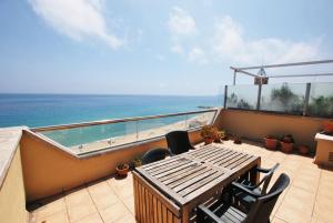 un balcone con tavolo e sedie e l'oceano di Waves and sky a Montgat