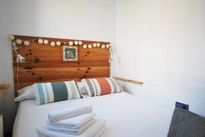 una camera da letto con un letto bianco con asciugamani sopra di Waves and sky a Montgat