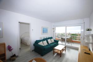 a living room with a green couch and a balcony at Narciso views in Vilassar de Mar