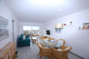a living room with a blue couch and a table at Narciso views in Vilassar de Mar