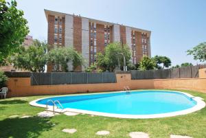 a swimming pool in a yard with a tall building at Narciso views in Vilassar de Mar