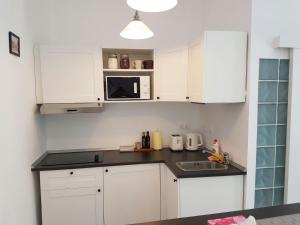 a kitchen with white cabinets and a sink at FLH - Studio Mai cu aroma de cafea si ceai in Sibiu +17 photos