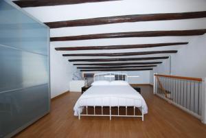 a bedroom with a white bed and a wooden ceiling at Cami Ral in Premiá de Mar