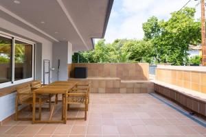 a patio with a wooden table and chairs at Aparthotel Vilassar in Vilassar de Mar