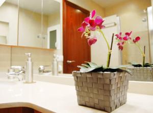 a bathroom sink with a vase with flowers in it at Panier en Osier · Panier en Osier · Charming apartment w/private terrace 2min from sea in Vilassar de Mar +46 photos