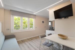 een keuken en woonkamer met een tafel en stoelen bij Aparthotel Vilassar in Vilassar de Mar