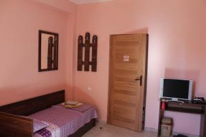 a bedroom with a bed and a door with a television at Hostel Victoria in Silistra