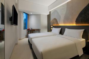 SimparにあるHotel Neo Kota Baru Parahyanganのテレビ付きのホテルの部屋にベッドが2つある +50枚の写真