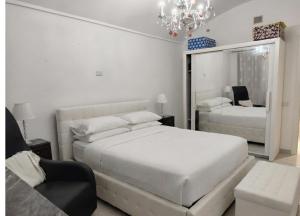 una camera da letto bianca con due letti e un lampadario di Da Marilena a Sorso