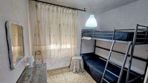 une chambre avec deux lits superposés et une fenêtre dans l'établissement Apartamento LOS BALCONES DE BARBATE, à Barbate