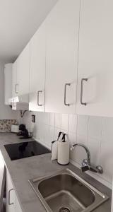 - une cuisine avec un évier et des placards blancs dans l'établissement Apartamento LOS BALCONES DE BARBATE, à Barbate 10 autres photos